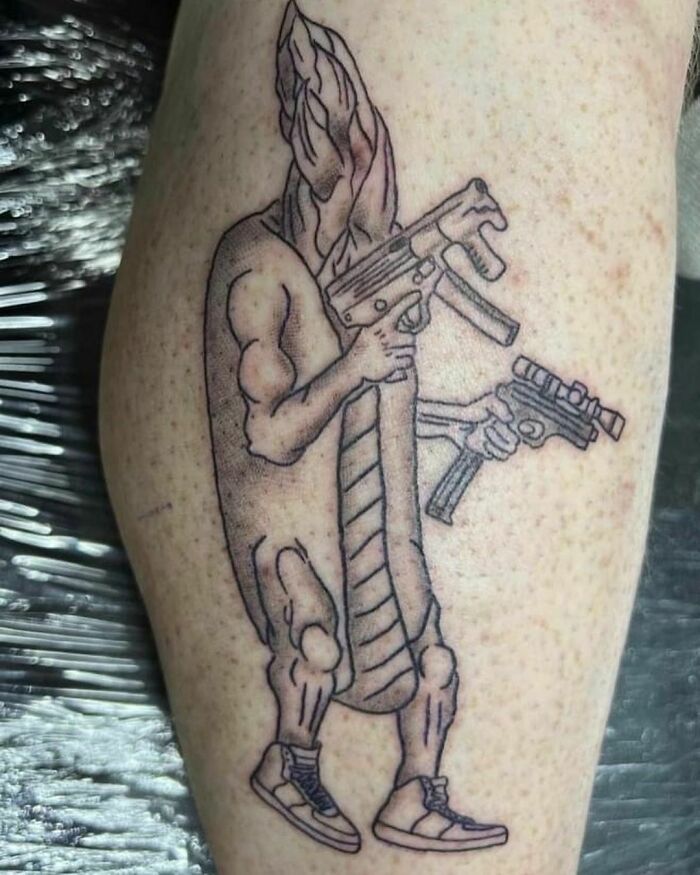 Failed tattoo depicting an anthropomorphic baguette holding guns.