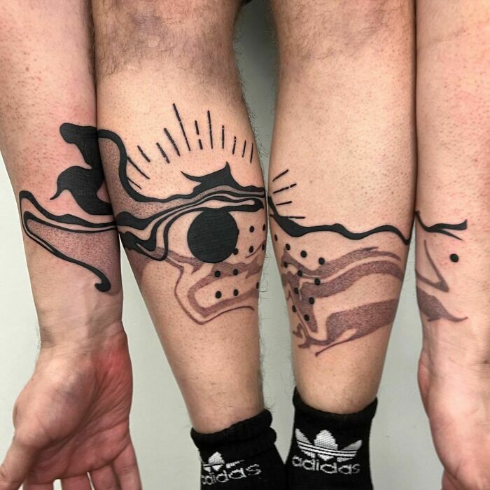 Creative artist's clever tattoo design with abstract patterns and hidden meanings on lower legs.