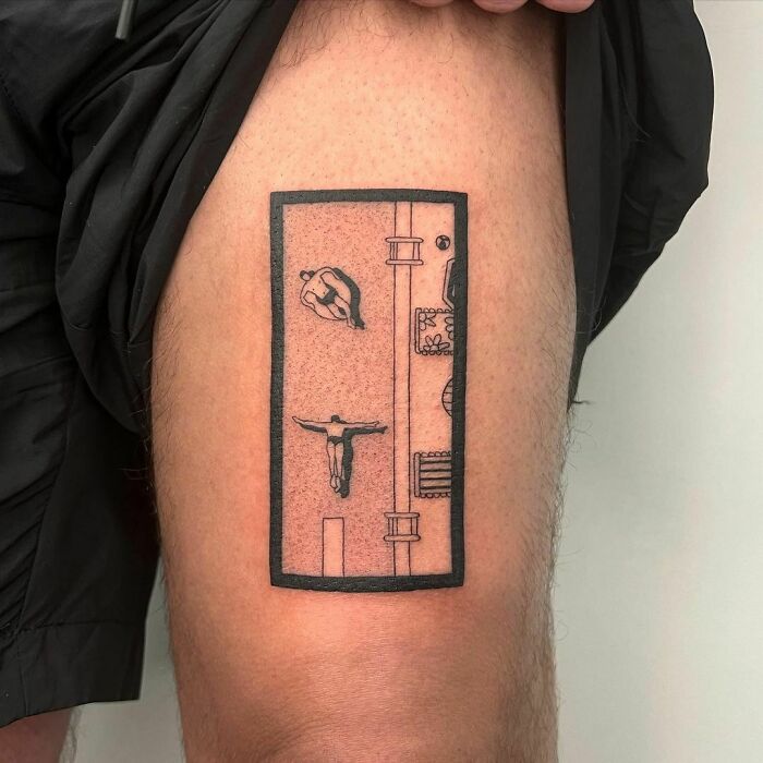 Tattoo of a diver inside a rectangular frame with hidden meaning on a person's thigh, designed by a creative artist.