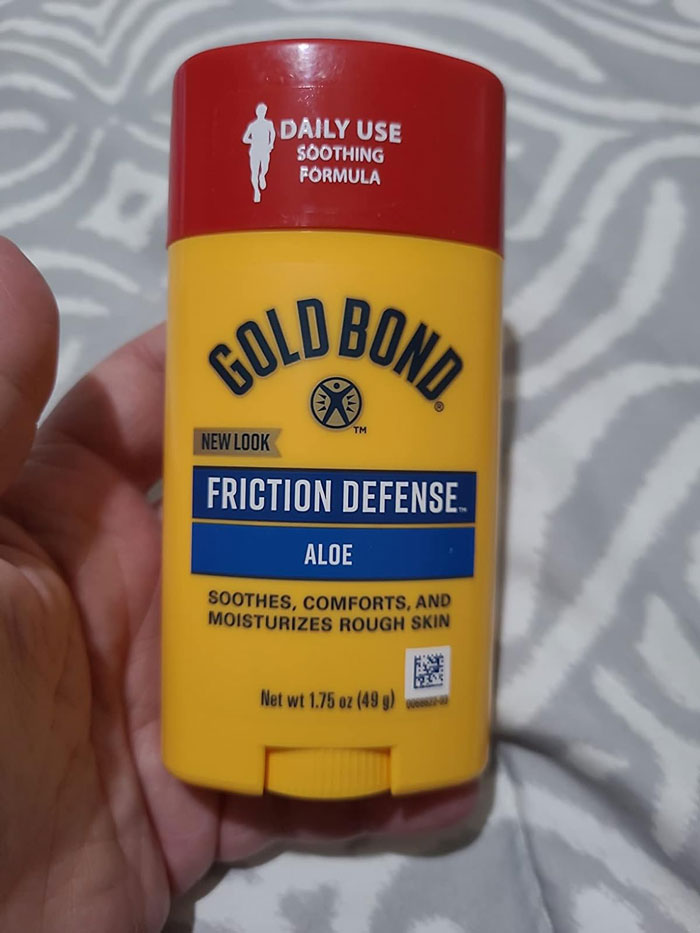 Hand holding Gold Bond Friction Defense aloe stick, a top life hack for soothing and moisturizing rough skin daily use.