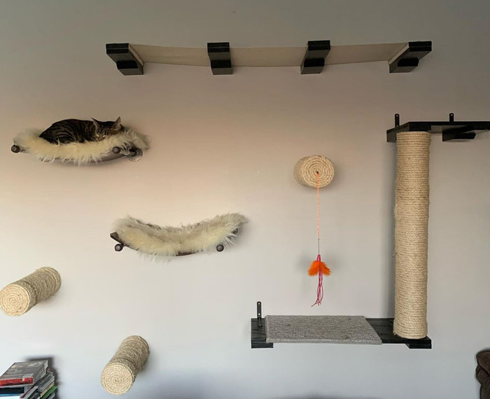 DIY cat tree tower with platforms, rope posts, and a hammock for a cozy feline play area.