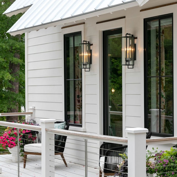 White house porch with wall sconces, furniture and flowers