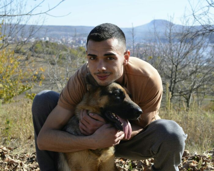 Man outdoors hugging a German Shepherd, showcasing dog breed characteristics. Man outdoors hugging a German Shepherd, showcasing dog breed characteristics.