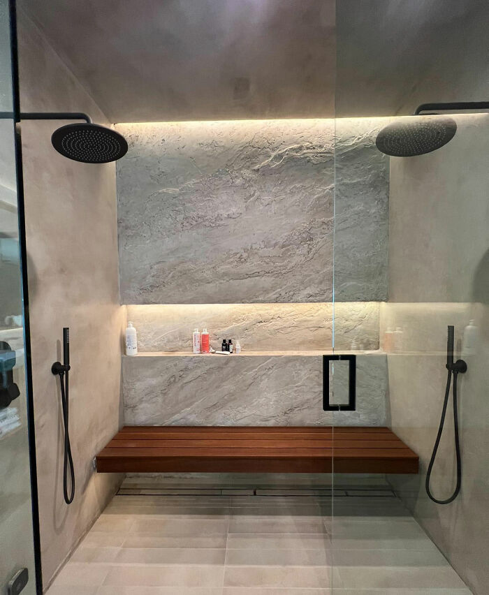 Spacious walk-in shower with a wooden bench 