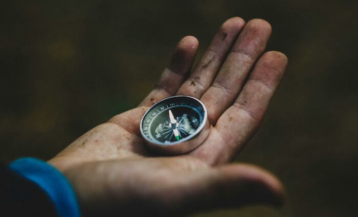 A person holding a compass in their hand, symbolizing being terrible at basic navigation.