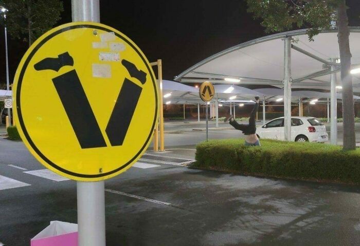 A humorous image of a person doing a handstand next to a sign depicting upside-down legs.