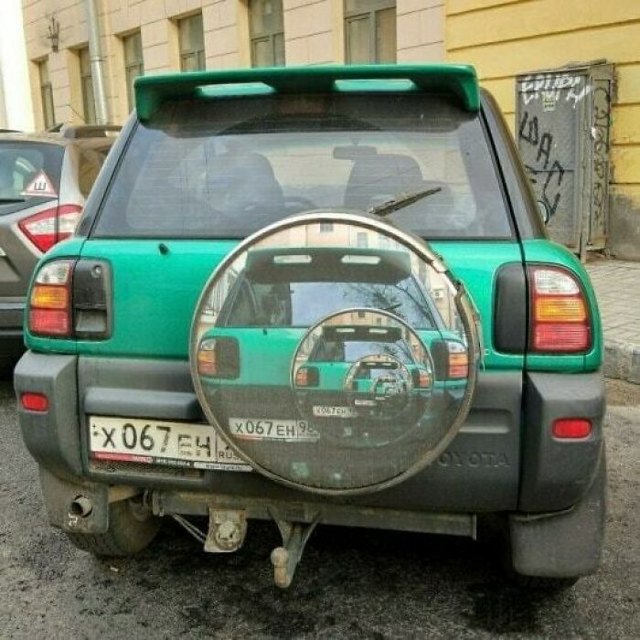A car with an infinite reflection on the spare tire cover, illustrating a humorous image needing no context.