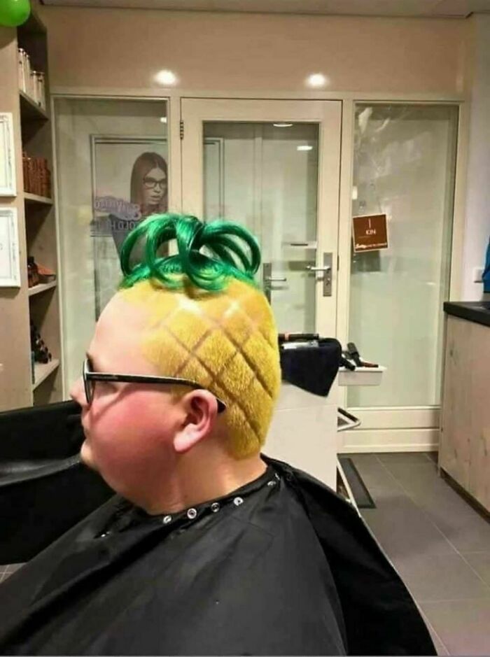 Person with a pineapple-inspired haircut, featuring green top and yellow crisscross pattern, in a salon setting.