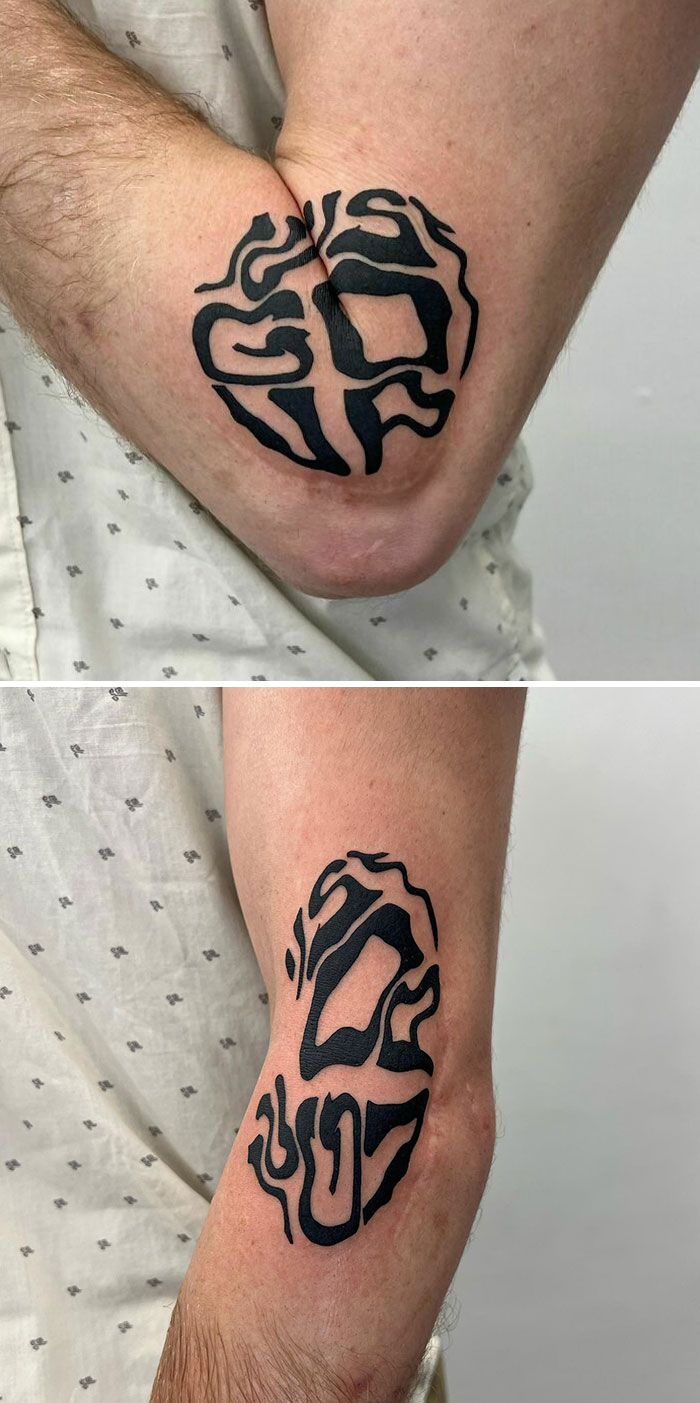 Creative artist's clever tattoo with hidden meaning on an arm, featuring bold, abstract black shapes.