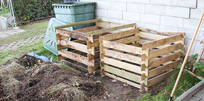 Two wooden boxes in a backyard ready to be filled with compost Two wooden boxes in a backyard ready to be filled with compost