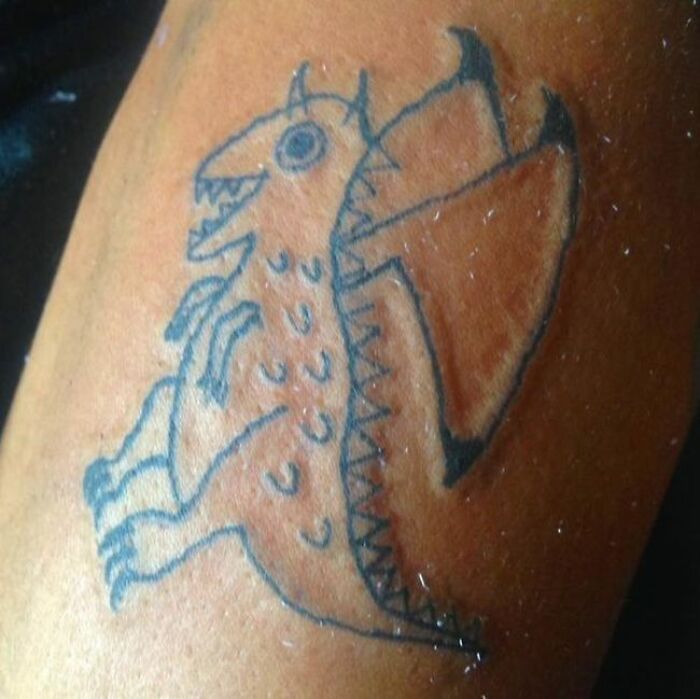 A poorly drawn dragon tattoo with uneven lines and proportions on skin; an example of failed tattoos.