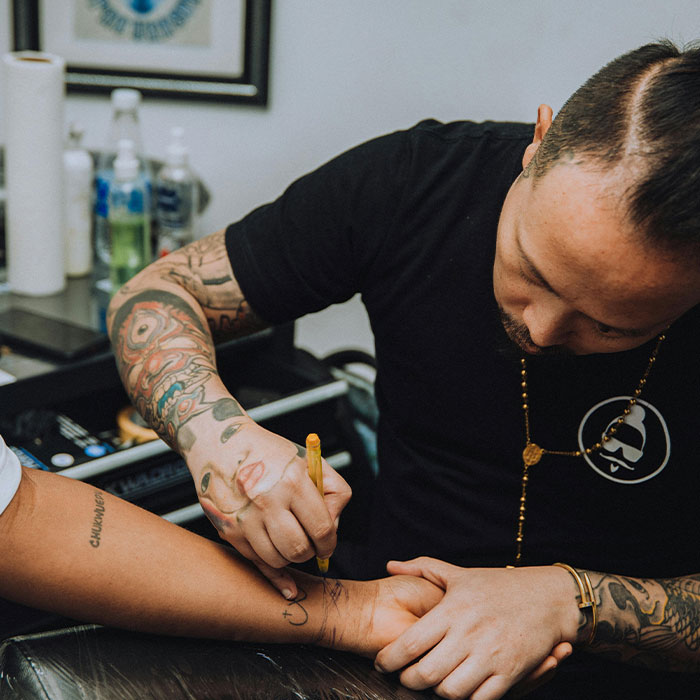 Tattoo artist applying ink, highlighting potential dangerous ingredients in US tattoo inks. Tattoo artist applying ink, highlighting potential dangerous ingredients in US tattoo inks.