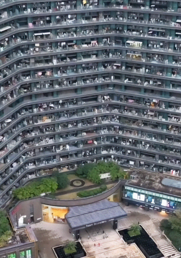 Massive Chinese apartment building with thousands of residents and connected indoor living spaces in a dystopian-style design.
