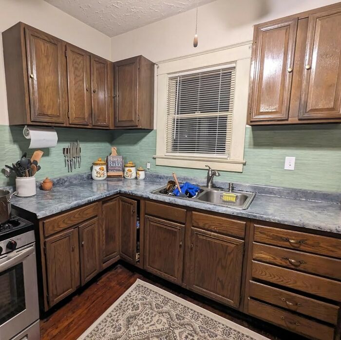 Cozy wood-cabinet kitchen with green backsplash, laminate counters, stainless sink and stove, kitchen feel like new