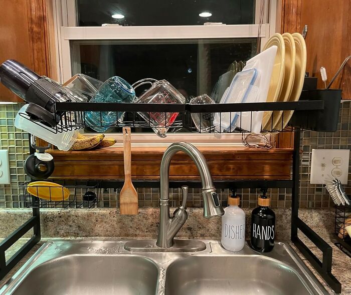Dish rack over double sink with dishes, modern faucet and soap dispensers, helping kitchen feel like new