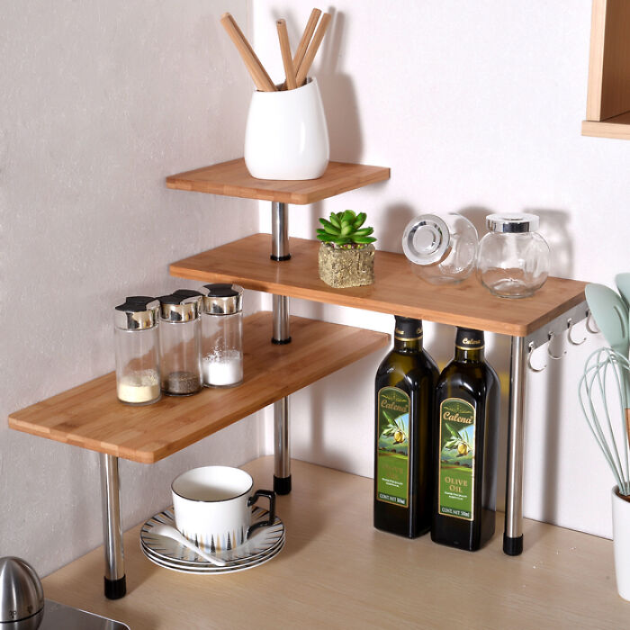 Corner bamboo shelving with olive oil bottles, spice jars, cup and succulent, kitchen feel like new