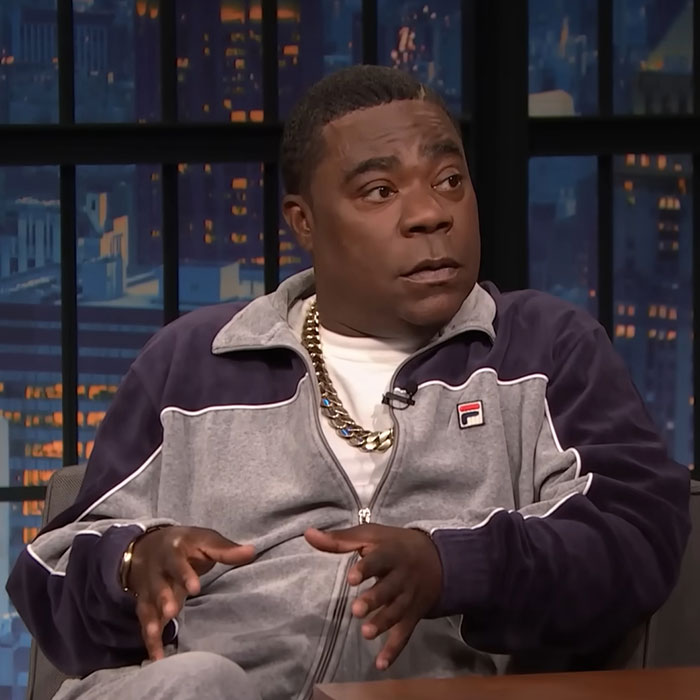 Man in a gray tracksuit speaking on a talk show, illustrating the concept of celebrities before cancel culture.