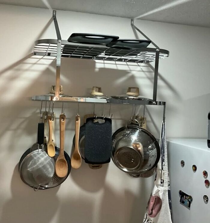 Overhead pot rack with pans, wooden spoons and colander, kitchen feel like new