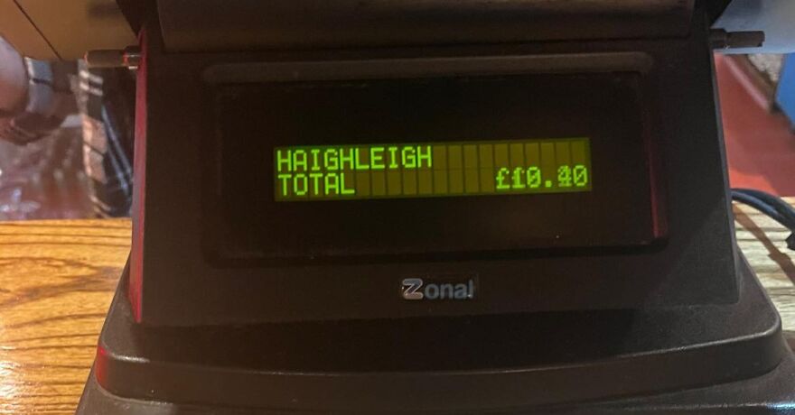 Cash register display showing a total for Haighleigh, highlighting funny unfortunate names on a bill in a cafe setting.