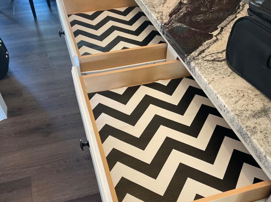 Chevron drawer liners in open drawers under granite countertop on dark wood floor, kitchen feel like new update