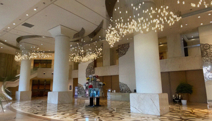 Spacious lobby area in a Chinese dystopian apartment building housing 20K residents with modern lighting and decor.