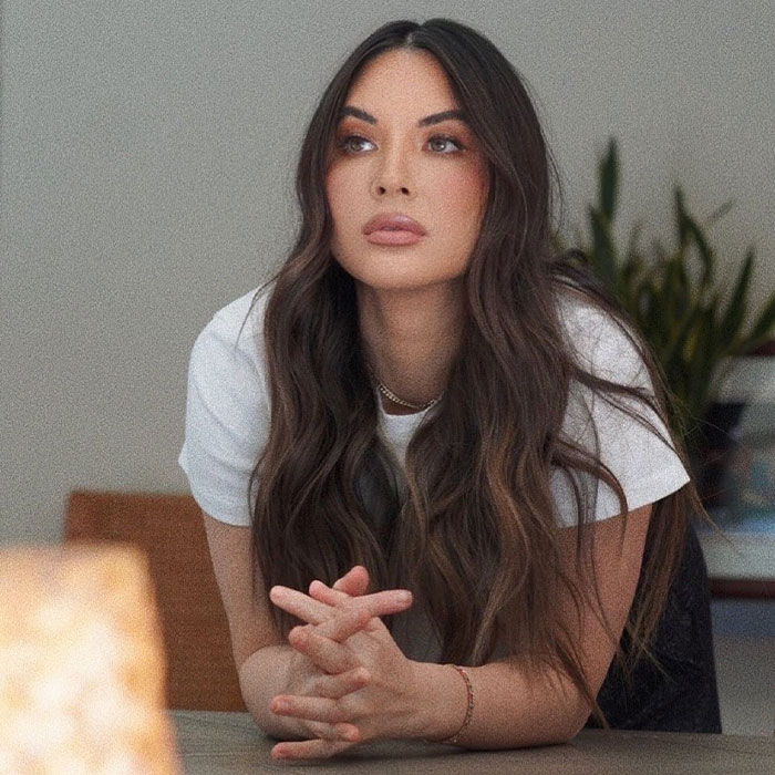 Woman with long hair sitting at a table, looking thoughtful. Main SEO keyword: "celebrities."