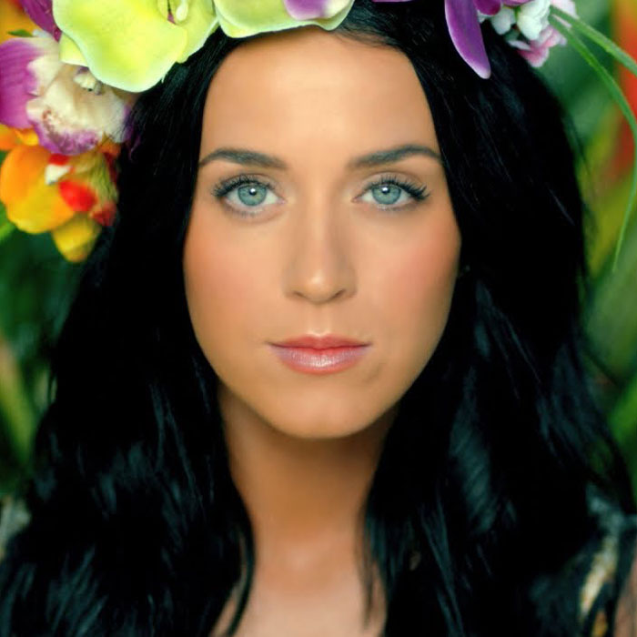 Close-up of a woman with dark hair and a flower crown, representing famous people accused of plastic surgery.