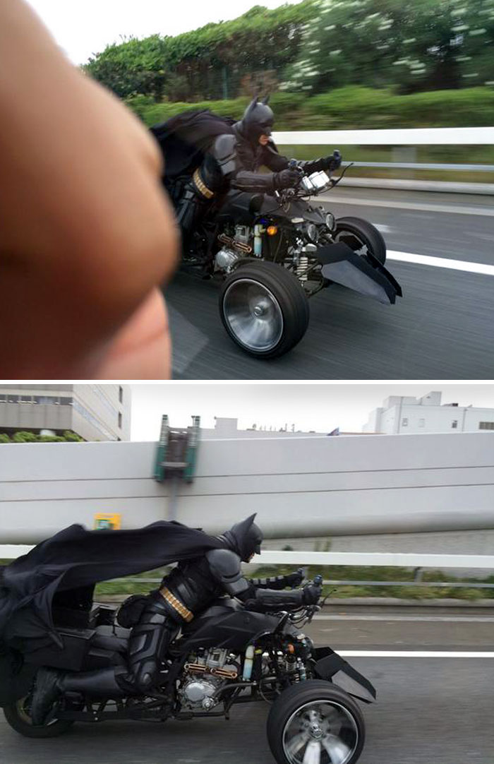 Person dressed as Batman riding a custom three-wheeled vehicle on a highway in Japan, showcasing unique culture.