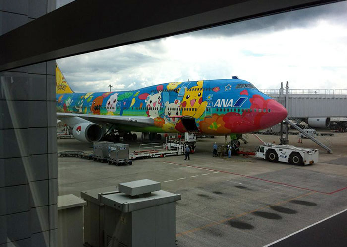 Colorful ANA airplane decorated with popular Japanese cartoon characters at an airport, highlighting Japan's unique culture.
