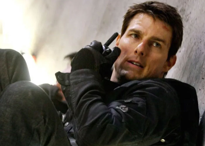 Actor Tom Cruise in a tactical outfit holding a walkie-talkie, representing famous people declining major awards.