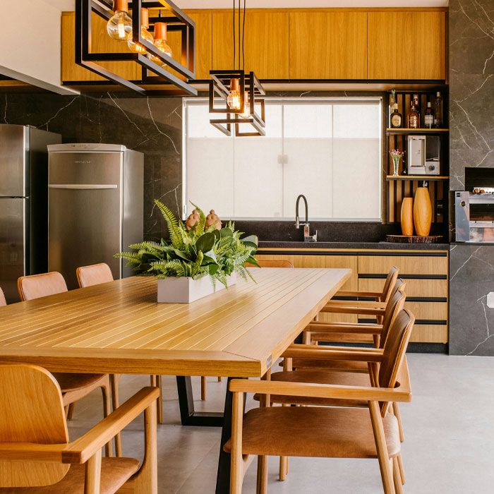 Light brown kitchen cabinets near light brown table and marble walls