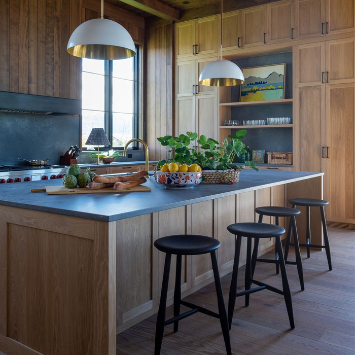 Light brown kitchen cabinets with open shelves and table near