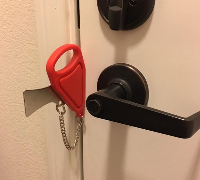 Door lock secured with a red portable door lock jammer, illustrating clever designs for easier and smarter home security.