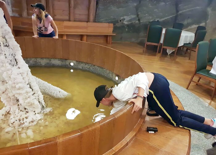 Tourist Stealing From A Fountain Where The Money Goes To Upkeep Of The Place And Charity