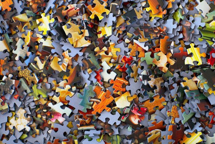 Scattered colorful puzzle pieces representing the challenge of solving advice that seemed like a joke until tried.