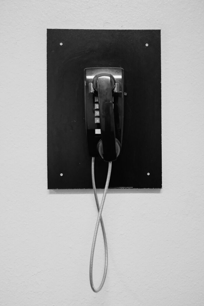 Vintage black wall phone mounted on a black panel illustrating trivia-worthy facts about the past and old technology.