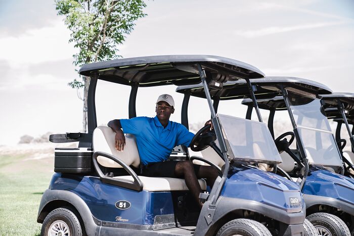 Man in blue shirt sitting in golf cart outdoors, illustrating people trying advice they initially thought was a joke