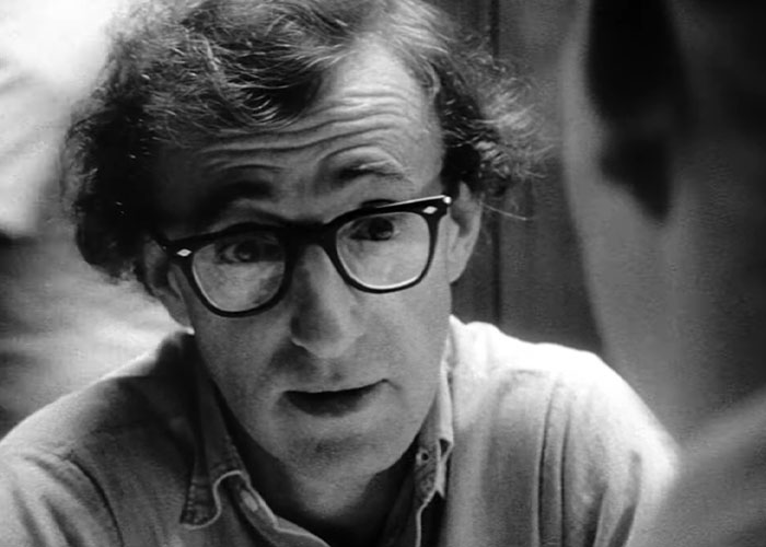 Black and white image of a man with glasses engaged in conversation, illustrating famous people declining major awards.