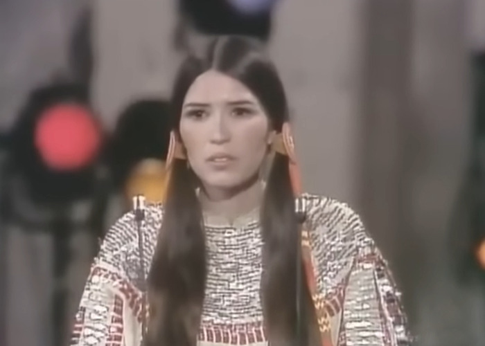 Woman in traditional attire speaking at a podium, related to famous people declining major awards and honors.