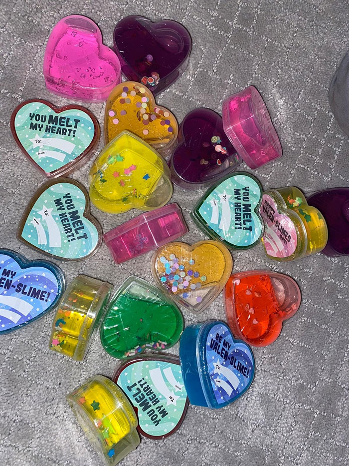 Valentine's Day gifts for kids: colorful heart-shaped slime containers on a gray carpet.