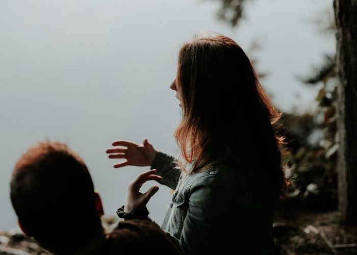 Two people talking outdoors by the water, reflecting on things they didn’t know until embarrassingly late in life.