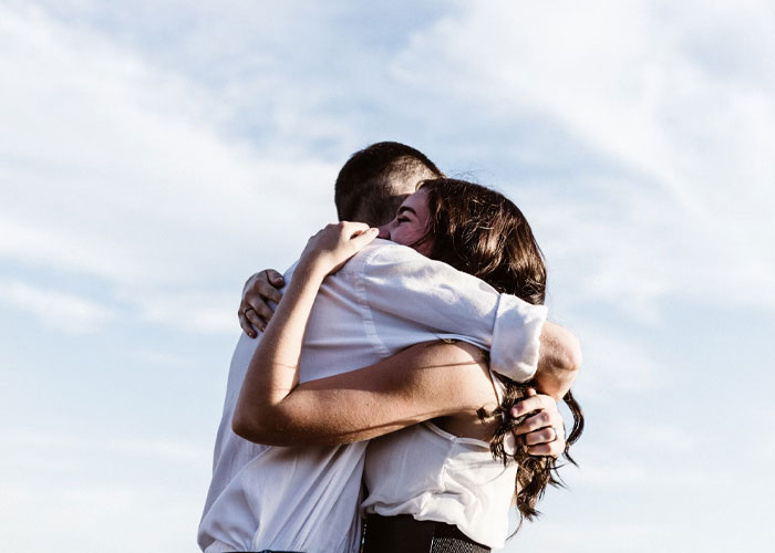 Couple embracing outdoors with smiles, representing childfree people over 40 reflecting on life choices and personal fulfillment.
