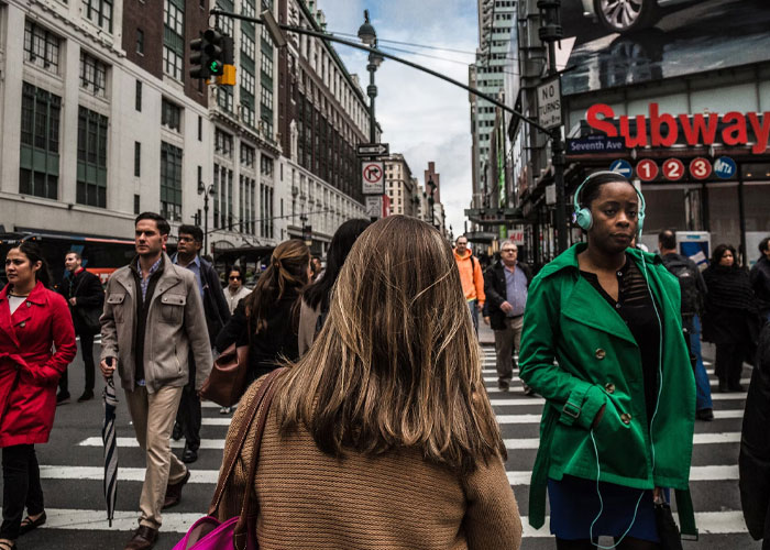Crowded city street scene showing diverse people walking near subway entrance, illustrating unexpected life discoveries.