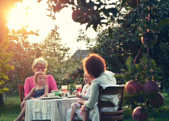 Family members enjoying a sunny afternoon in an orchard, reflecting on childfree people over 40 and life choices.