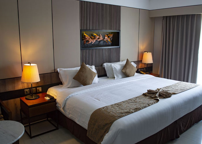 Modern hotel bedroom with a large bed, bedside lamps, and minimalist decor, perfect for comfort and relaxation.
