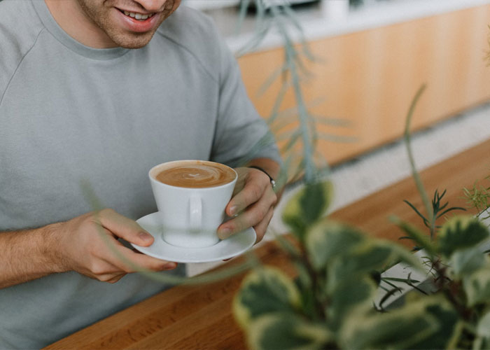 Person over 40 enjoying coffee in a cozy setting, representing childfree people reflecting on life choices and regrets.
