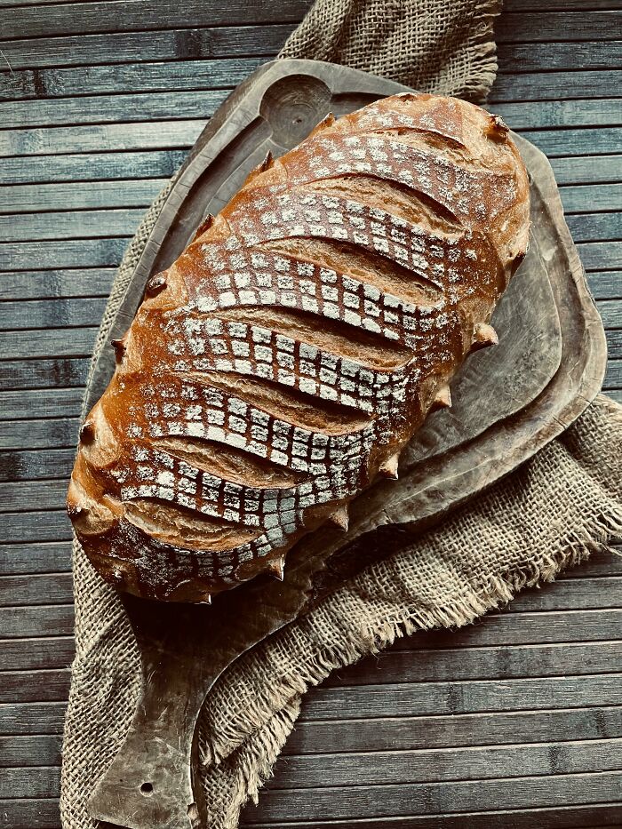 Artisan bread with perfect scoring and pattern, showcasing precision and skill in food presentation and baking perfection.