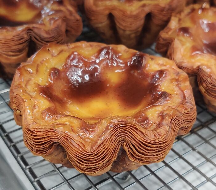 Crispy layered pastry with perfectly caramelized custard filling, showcasing food perfection and baking skill on a cooling rack.