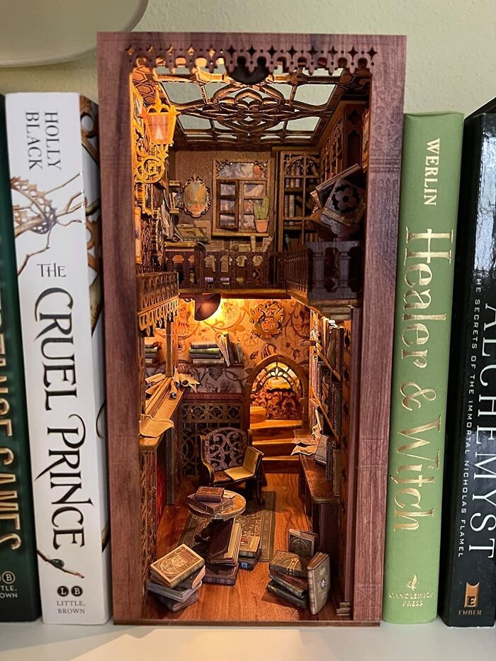 Intricately detailed miniature book nook between novels, showcasing a cozy reading room hobby where trying your best is key.