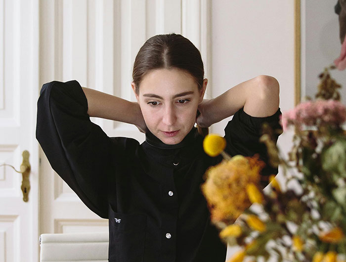 Woman setting boundaries with neighbor about free babysitting over summer, showing stress and resolve in home setting.